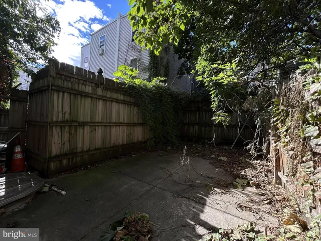 a view of backyard and wooden fence