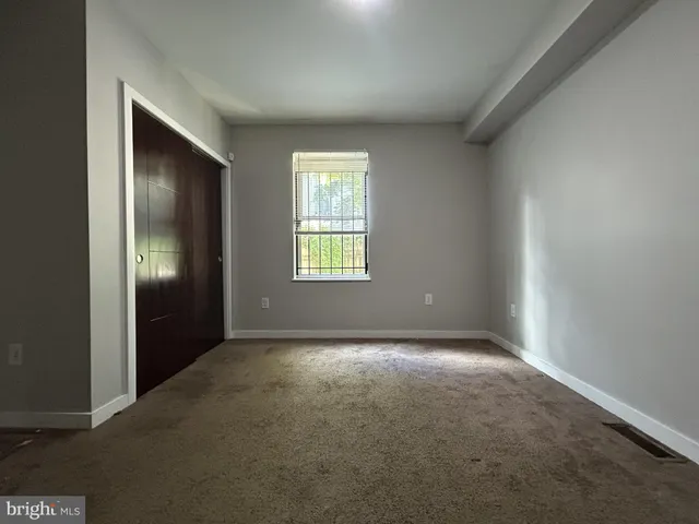 an empty room with windows and closet