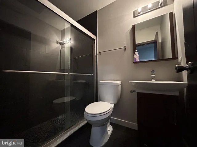 a bathroom with a toilet a sink and mirror