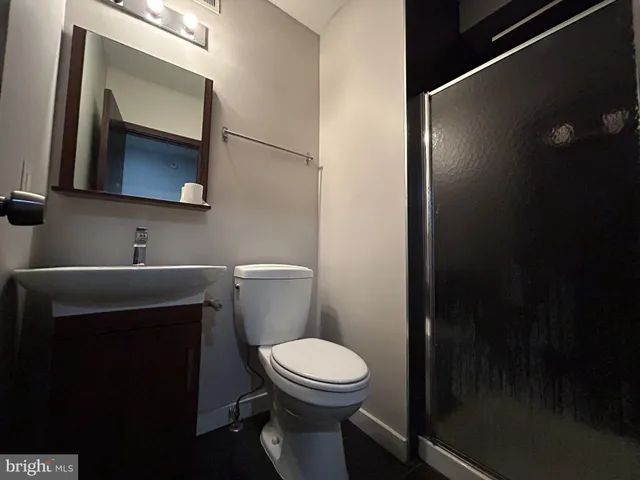 a bathroom with a toilet a sink and mirror