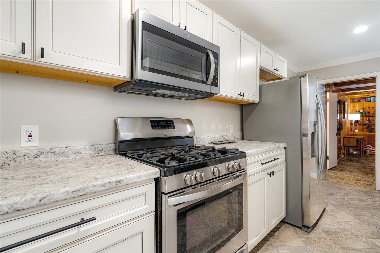 1629 Delmont Road Memphis, TN 38117 - Photo 13 of 32 a kitchen with stainless steel appliances granite countertop white cabinets and a stove top oven