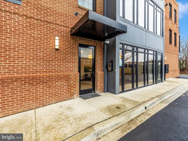 a kitchen with granite countertop a stove and white cabinets with wooden floors