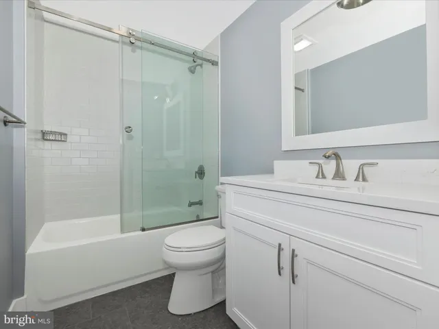 an empty room with ceiling fan and window