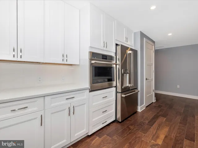 a kitchen with stainless steel appliances granite countertop a stove and a wooden floors