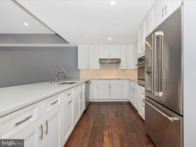 a view of a kitchen with wooden floor and a sink