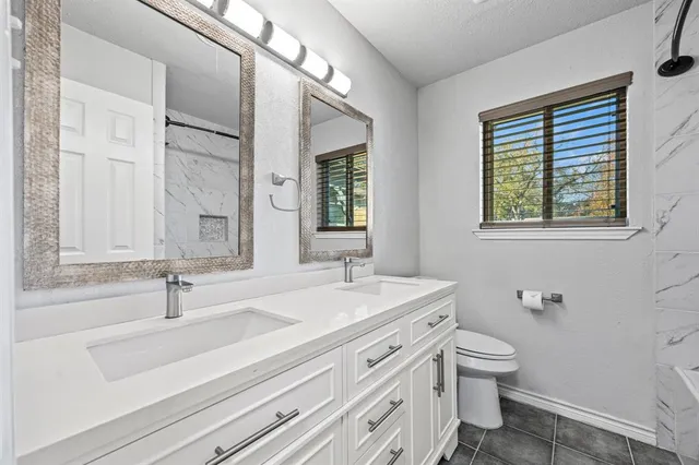 a bathroom with a sink toilet a mirror and window