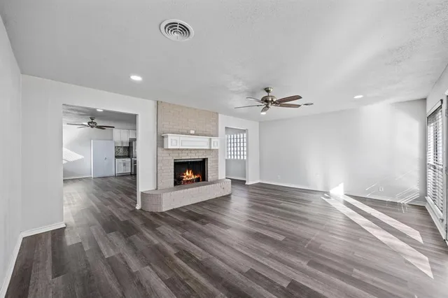 a view of a livingroom with wooden floor and a fireplace