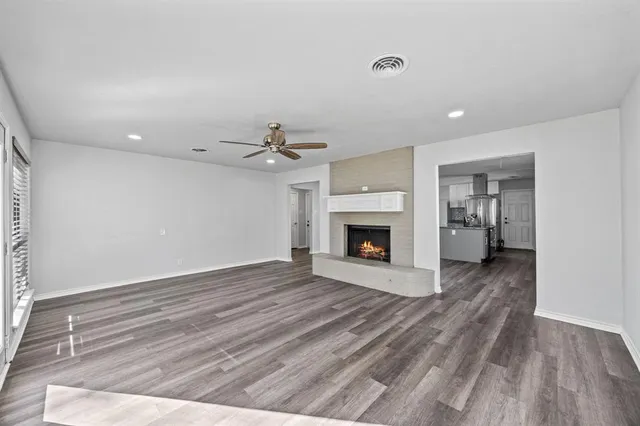 a view of empty room with wooden floor and fireplace