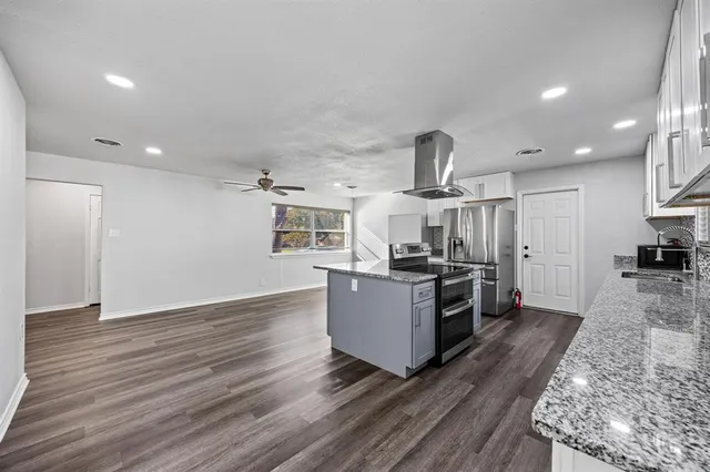 a kitchen with granite countertop a stove and a sink