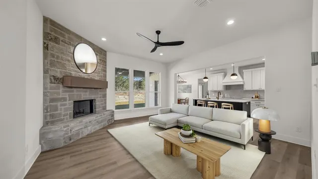 a living room with furniture a fireplace and a large window