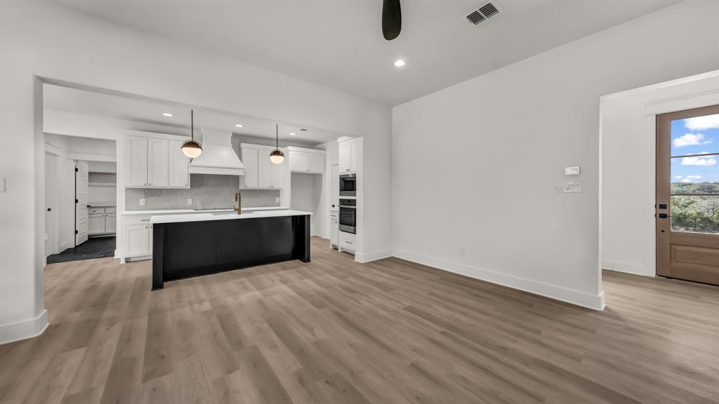 225 Jefferson Way Weatherford, TX 76088 - Photo 5 of 35 a large kitchen with stainless steel appliances kitchen island a large counter top and wooden floors