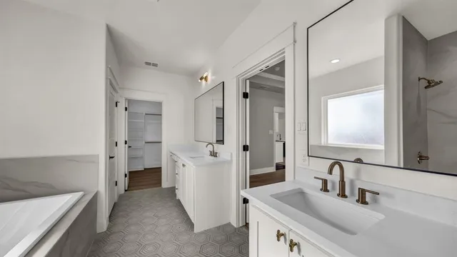 a bathroom with a tub sink and mirror
