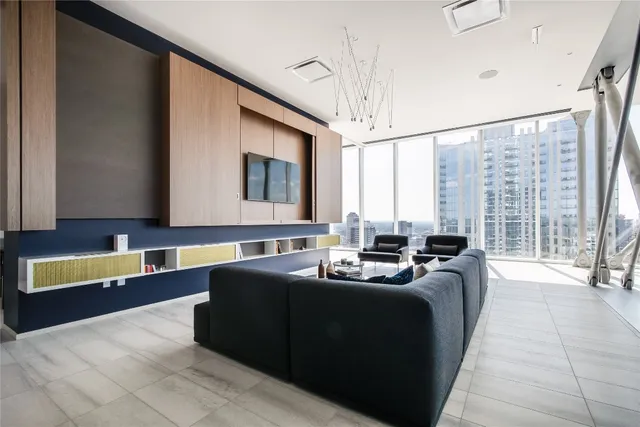a living room with couches bookshelf and a large window