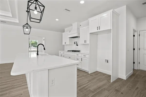 a kitchen with white cabinets and stainless steel appliances