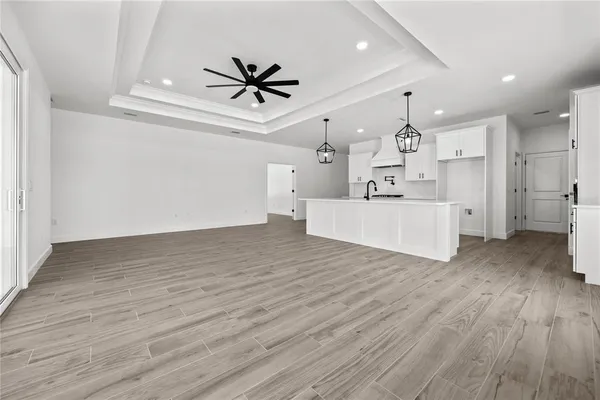 a view of empty room with wooden floor and ceiling fan