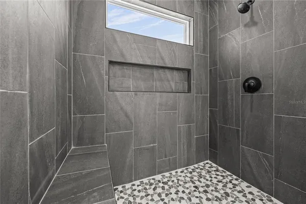 a bathroom with a double vanity sink a toilet and shower