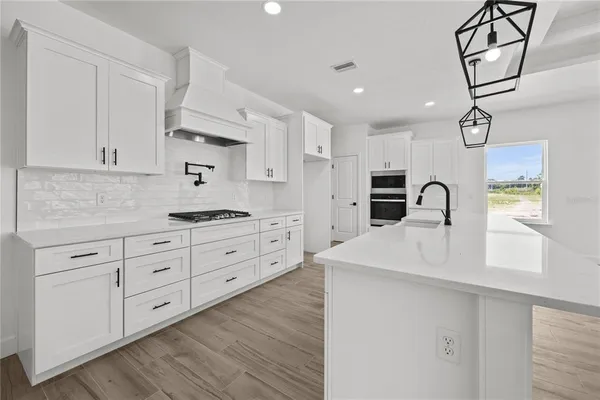 a kitchen with white cabinets stainless steel appliances and sink