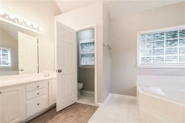 a view of bathroom with bathtub mirror and window