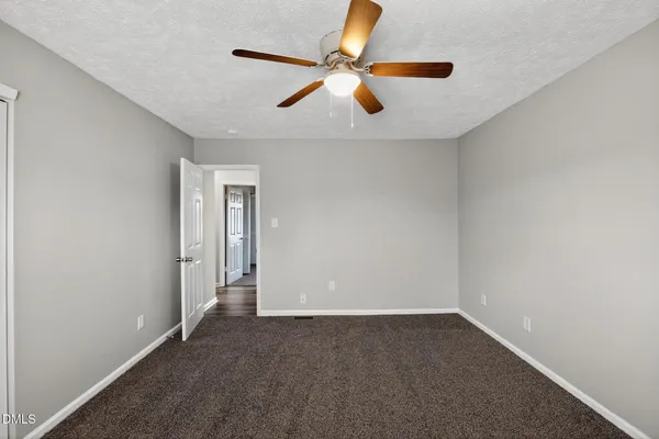 an empty room with closet and ceiling fan