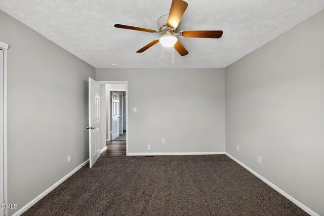 an empty room with closet and ceiling fan