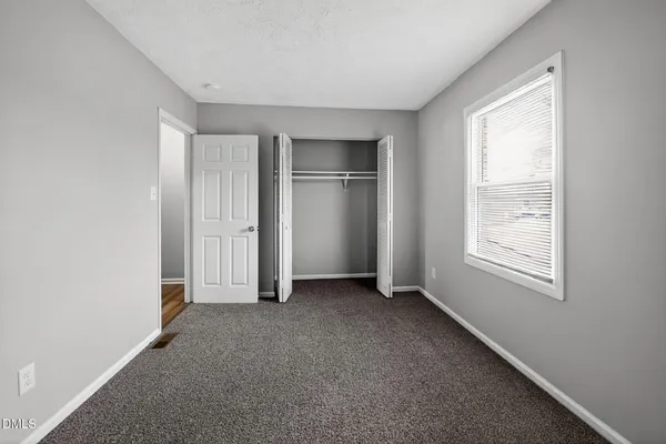 a view of an empty room with closet area