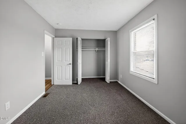 a view of an empty room with closet area