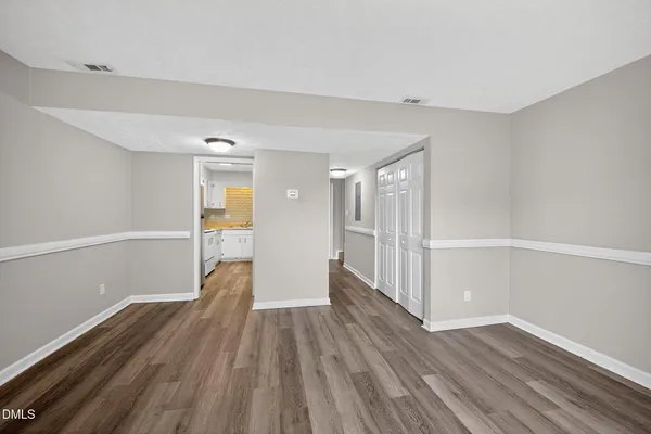 a view of a big room with wooden floor and windows