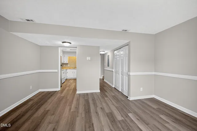 a view of a big room with wooden floor and windows