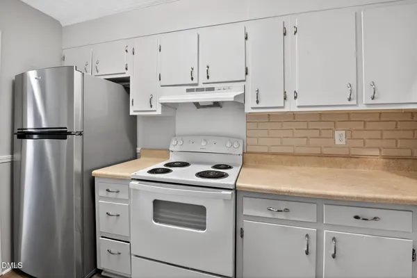a kitchen with appliances a refrigerator and cabinets