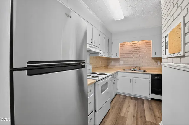 a kitchen with granite countertop white cabinets and white appliances