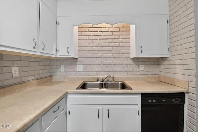 a kitchen with a sink a cabinets and a window