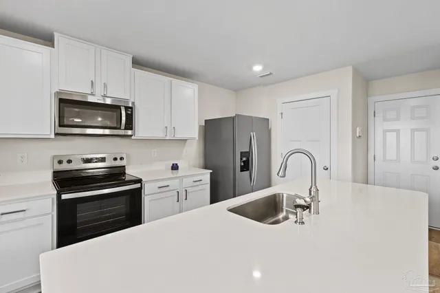 a kitchen with sink a microwave and refrigerator