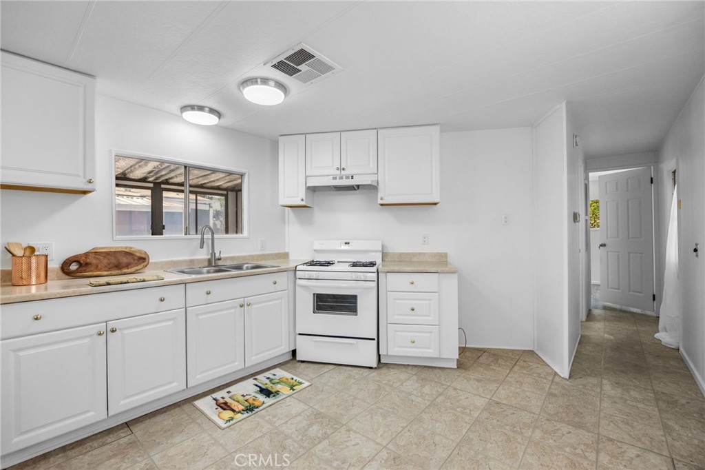 995 Pomona Road, Unit 88 Corona, CA 92882 - Photo 24 of 31 a kitchen with granite countertop a sink stainless steel appliances and cabinets