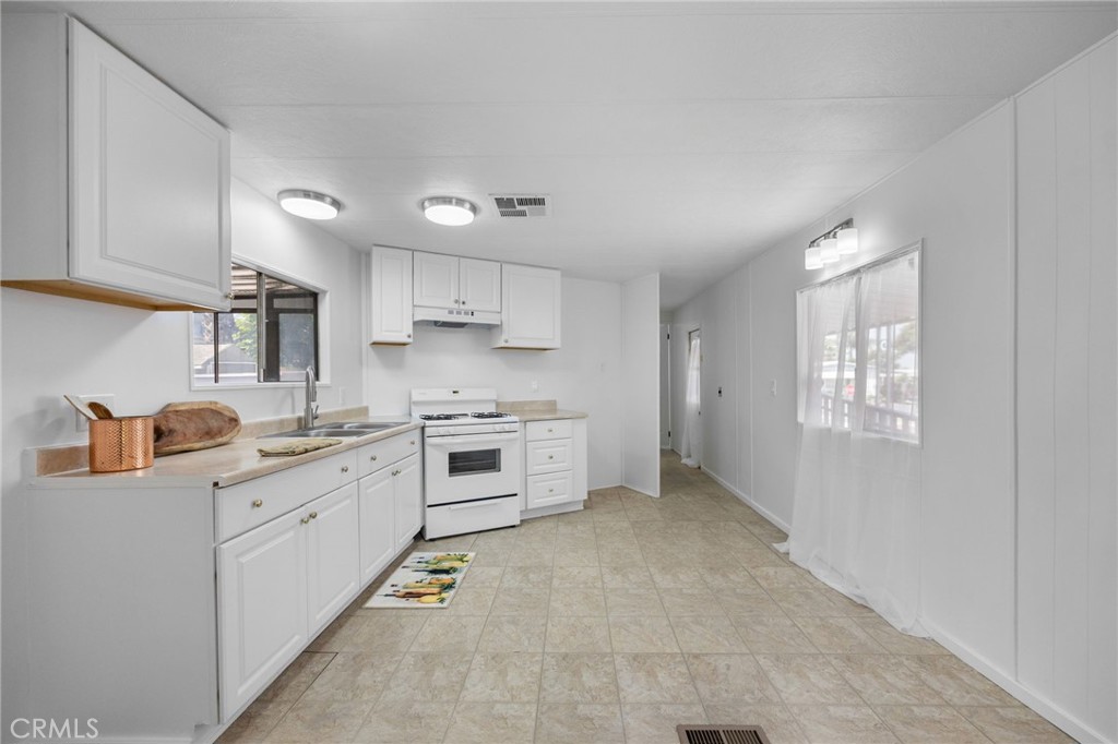 995 Pomona Road, Unit 88 Corona, CA 92882 - Photo 25 of 31 a kitchen with granite countertop cabinets and white appliances