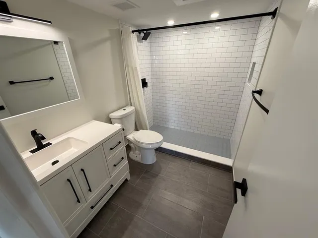 a bathroom with a sink mirror vanity and toilet