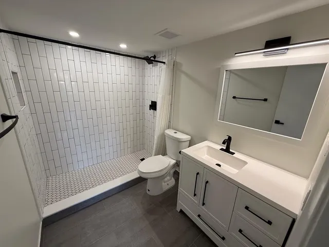 a bathroom with a sink a toilet and shower