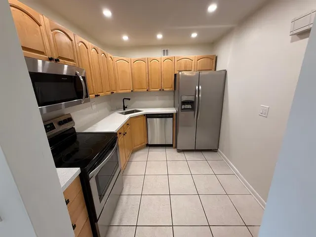 a kitchen with stainless steel appliances a refrigerator sink and stove