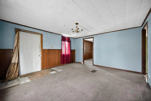an empty room with windows and refrigerator
