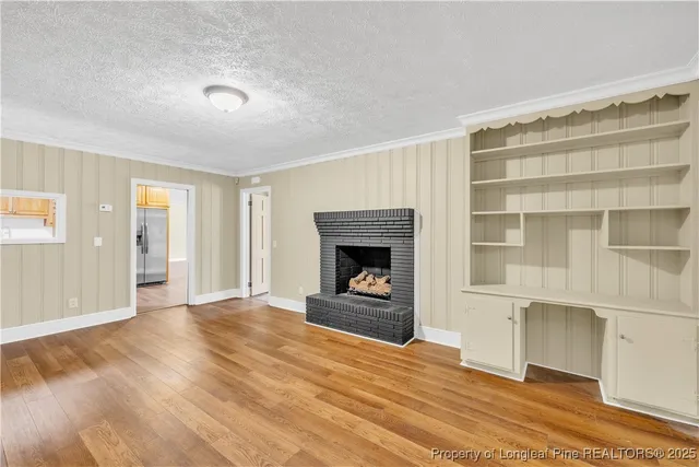 a view of an empty room with a fireplace and a window