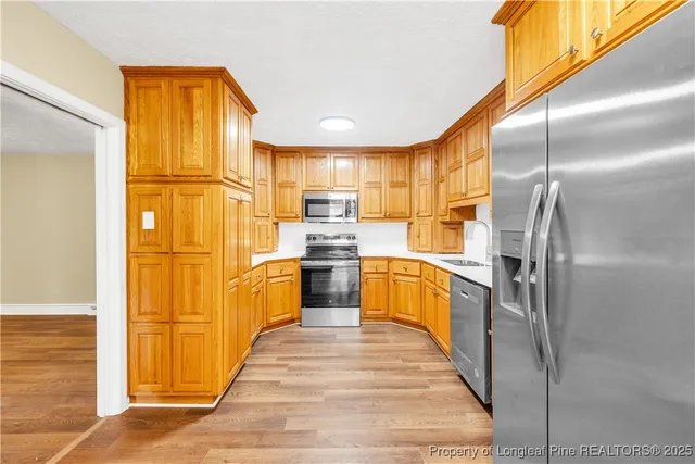 a kitchen with stainless steel appliances granite countertop a refrigerator a sink dishwasher with a dining table and chairs