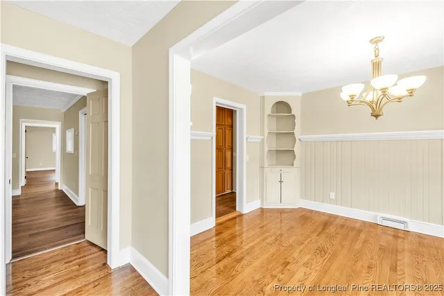 a view of a bedroom with wooden floor and cabinet