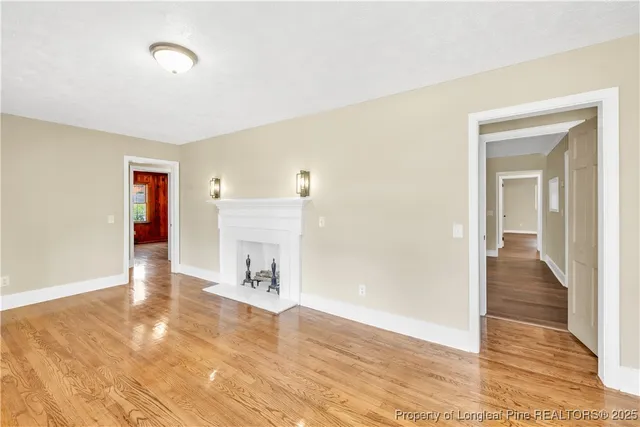 a view of a hallway with wooden floor and a living room