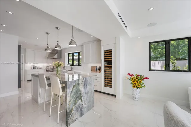 a view of a kitchen with kitchen island granite countertop wooden floor and a sink