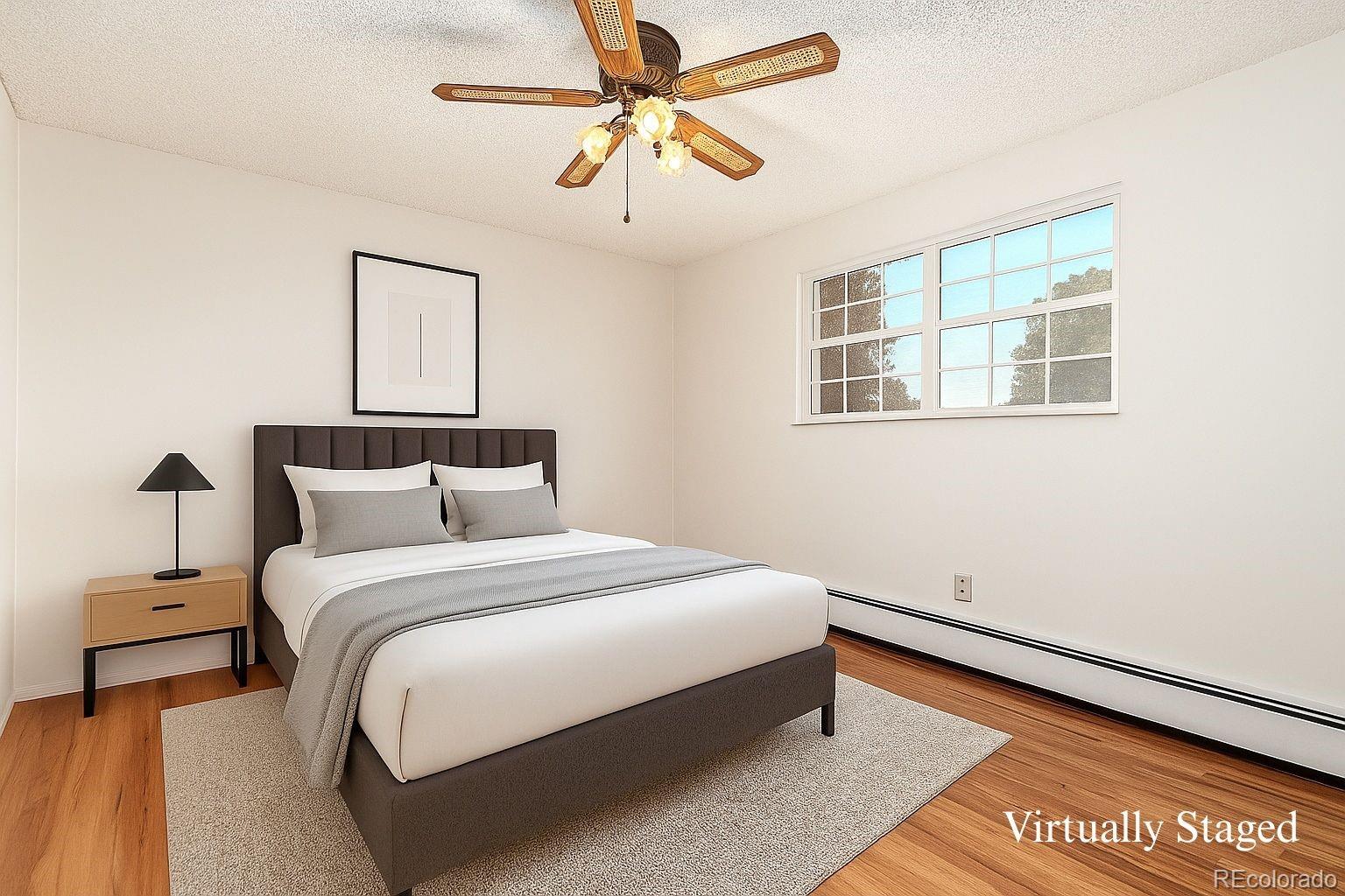 8976 West 46th Place, Unit 8976 Wheat Ridge, CO 80033 - Photo 2 of 10 a bedroom with a bed and a window