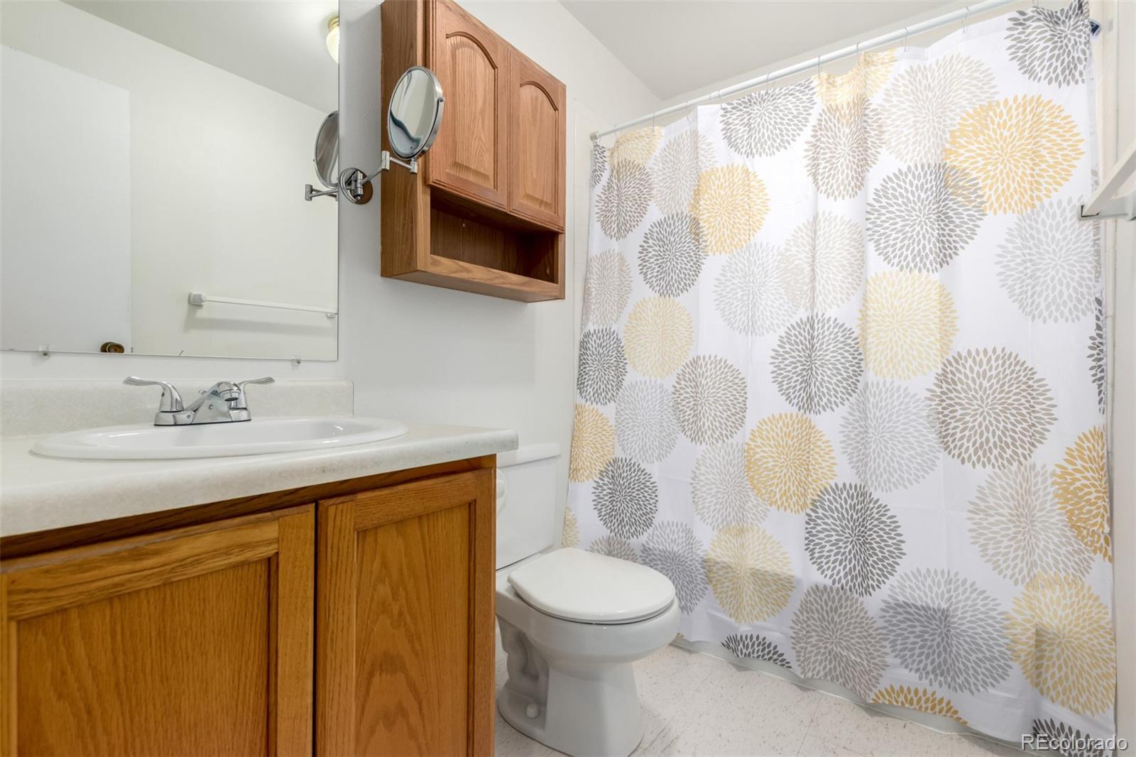 8976 West 46th Place, Unit 8976 Wheat Ridge, CO 80033 - Photo 6 of 10 a bathroom with a sink toilet and shower