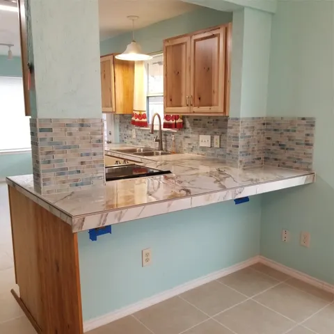 a kitchen with granite countertop a sink a stove and cabinets