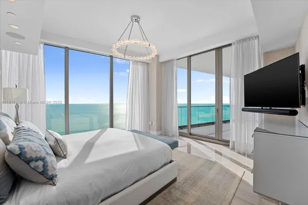 a bedroom with a bed and a chandelier