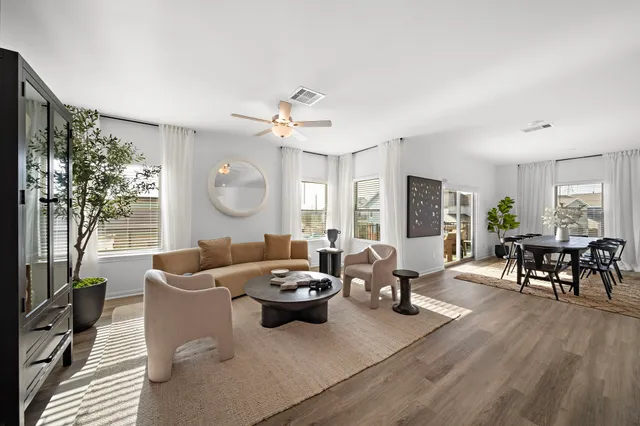 a living room with furniture potted plant and a large window