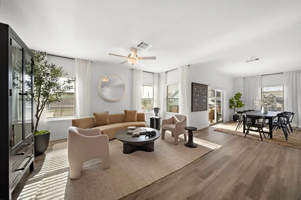 a living room with furniture potted plant and a large window
