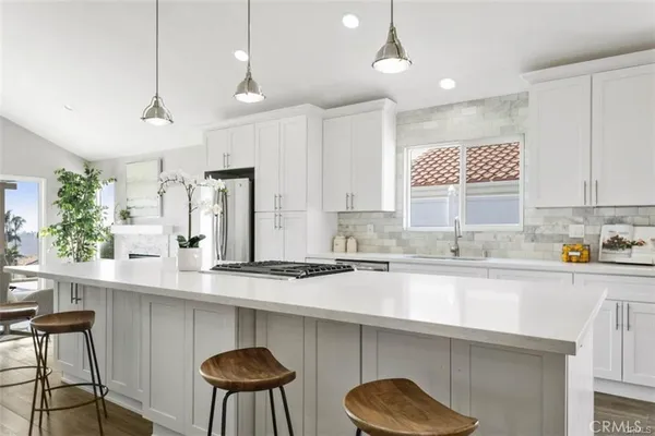 a kitchen with stainless steel appliances a sink a table chairs and a window